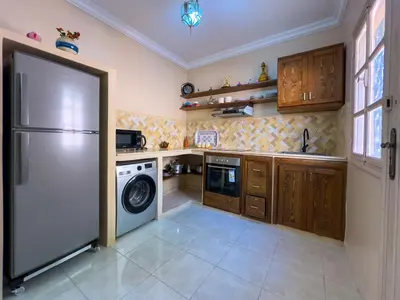 a kitchen with a refrigerator and a washing machine at Appartement lumineux avec Jardin à la palmeraie in Marrakech