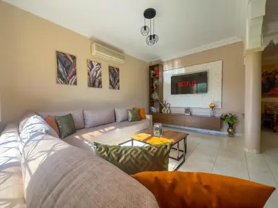 a living room with a couch and a table at Appartement lumineux avec Jardin à la palmeraie in Marrakech