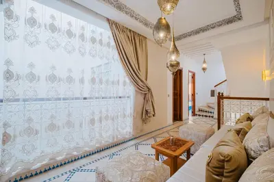 a living room with a couch and a large window at Riad Marrakech Dar Tivawin 3 rooms With Pool Private Riad in Marrakech