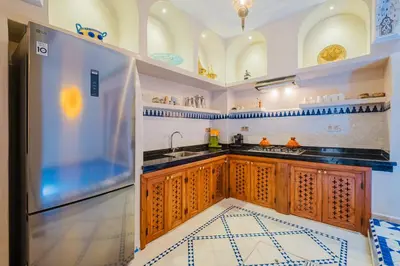 a kitchen with a sink and a refrigerator at Riad Marrakech Dar Tivawin 3 rooms With Pool Private Riad in Marrakech
