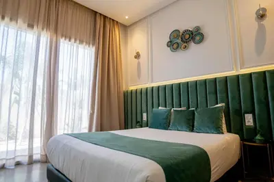 a bedroom with a large bed with a green headboard at Villa Seyana 1 Zero Vis a Vis et Piscine Chauffee in Marrakech