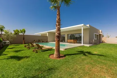 a house with a palm tree and a swimming pool at Villa Seyana 1 Zero Vis a Vis et Piscine Chauffee in Marrakech