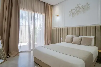 a bedroom with a large bed and a large window at Villa Seyana 2 Zero vis a vis, Piscine Chauffee in Marrakech
