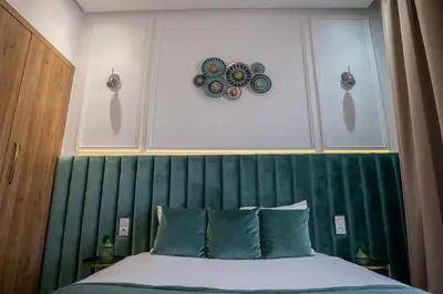 a bedroom with a bed with a green headboard at Villa Seyana 2 Zero vis a vis, Piscine Chauffee in Marrakech