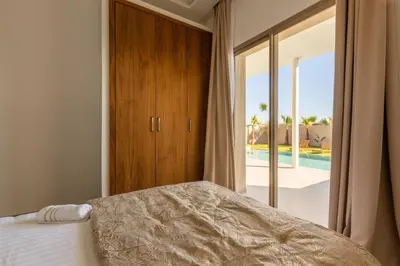 a bedroom with a bed and a view of a pool at Villa Seyana 5 Zero vis a vis Piscine chauffee in Marrakech