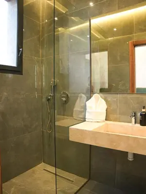 a bathroom with a shower with a sink and a mirror at Villa Crystale - Marrakech in Marrakech