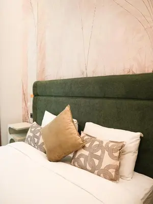 a bed with a green headboard and some pillows at Villa Crystale - Marrakech in Marrakech