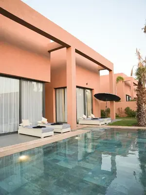 a hotel with a swimming pool in front of a building at Villa Crystale - Marrakech in Marrakech