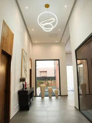 a hallway with chairs and a door with a chandelier at Villa Crystale - Marrakech in Marrakech