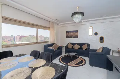 a living room with a table and a couch at Superbe Appart 3 pièces Moderne, Confort avec vue panoramique sur Marrakech plein centre à 7 min a pied de Gueliz in Marrakech