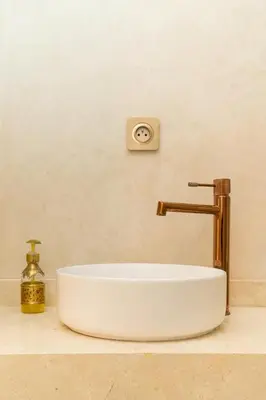 a white bathroom sink with a gold faucet at fantastic Apartment in Marrakech