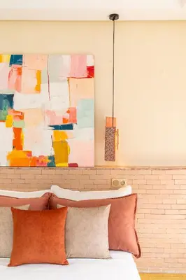 a bed with pillows in front of a painting at fantastic Apartment in Marrakech