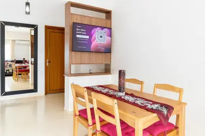 a dining room with a table and a television at Kridarek - Appartement Élégant à Marrakech in Marrakech