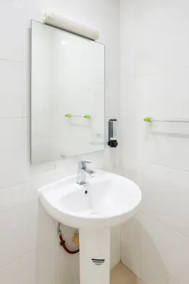a white bathroom with a sink and a mirror at Kridarek - Appartement Élégant à Marrakech in Marrakech