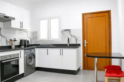 a kitchen with a washing machine and a table at Kridarek - Appartement Élégant à Marrakech in Marrakech