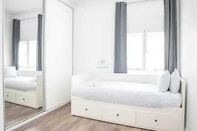 a white bedroom with two beds and mirrors at Kridarek - Appartement Élégant à Marrakech in Marrakech