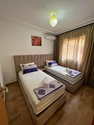 a bedroom with two beds and a window at Cozy & Elegant apartment Marrakech in Marrakech
