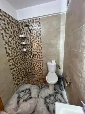 a bathroom with a toilet and a walk in shower at Cozy & Elegant apartment Marrakech in Marrakech