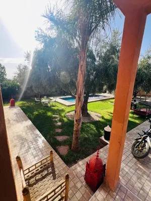 a view of a park with a bench and a tree at Excellente Villa A Proximité De Marrakech in El Aïn