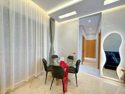 a dining room with a glass table and chairs at elegance apartment in Marrakech in Marrakech