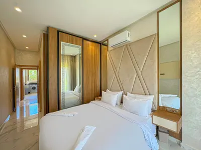 a bedroom with a large white bed and a bathroom at elegance apartment in Marrakech in Marrakech