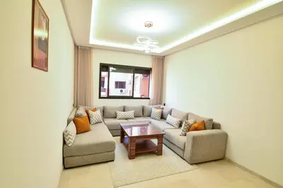 a living room with a couch and a table at Superbe T3 neuf - Proche centre - Piscines et Clim - Marrakeck in Marrakech
