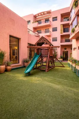 a playground in the courtyard of a building at Appartement spacieux centre ville quartier dynamique in Marrakech