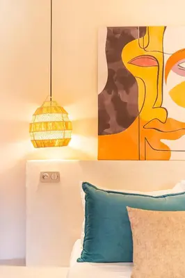 a room with a couch and a painting and a lamp at Cosy appartement avec jacuzzi in Marrakech