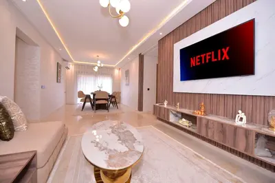a living room with a television on a wall at Appart Essalam in Marrakech