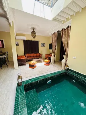 a large swimming pool in a living room with a couch at Riad LALA ASMAA Riad privé in Marrakech