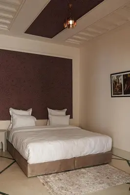a bedroom with a large bed with white pillows at Palais Andara Riad And SPA in Marrakech