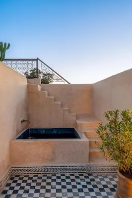 a bath tub in the middle of a building with stairs at Riad Litote in the heart of the Kasbah in Marrakech
