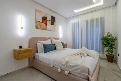 a bedroom with a large bed and a window at Modern Hivernage Studio Retreat Pool & central access in Marrakech