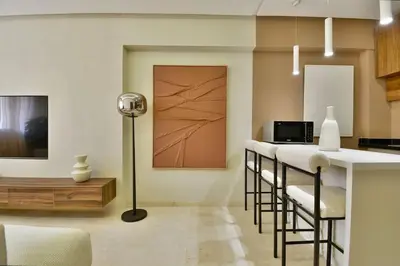 a kitchen with a bar with chairs and a table at Appartement Gueliz Haut de gamme Residence 5 piscines in Marrakech