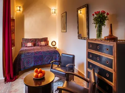 a bedroom with a bed and a bowl of fruit on a table at Riad Darhani in Marrakech
