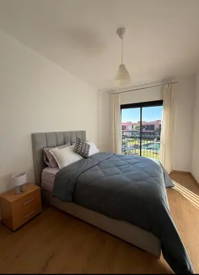 a bedroom with a large bed and a window at Appartement au Domaine de Noria - Terrasse & Piscine in Marrakech