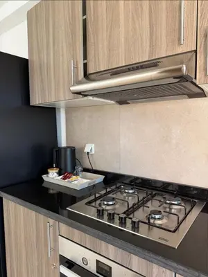 a kitchen with a stove top in a kitchen at Appartement au Domaine de Noria - Terrasse & Piscine in Marrakech