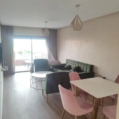 a living room with a couch and a table and chairs at T3 Jade Prestigia Pool in Marrakech