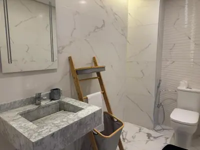 a bathroom with a marble sink and a toilet at Magnifique appartement avec piscine in Marrakech