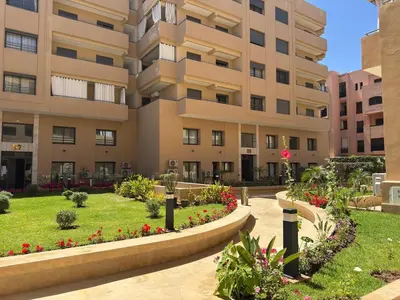 a building with a garden in front of it at Magnifique appartement avec piscine in Marrakech