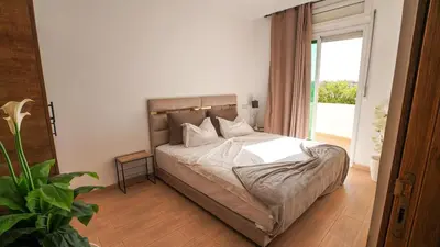 a bedroom with a bed and a large window at Stylish apartment with pool access heart of Marrakech gueliz in Marrakech