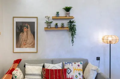 a living room with a couch and a portrait of a woman at Modern Apt with Balcony & Pool in Central Marrakesh in Marrakech