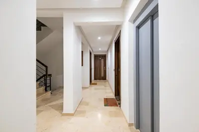 a hallway of a house with white walls and floors at Modern Apt with Balcony & Pool in Central Marrakesh in Marrakech