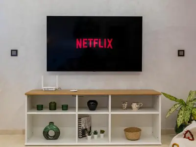 a flat screen tv on a white entertainment center at Modern Apt with Balcony & Pool in Central Marrakesh in Marrakech