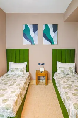 two beds with green headboards in a bedroom at Appartement HIVERNAGE deLUXE en face consulat de france et M avenu CR7 in Marrakech