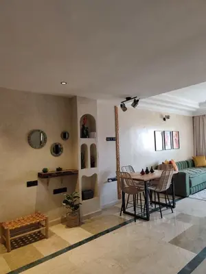 a living room with a table and a couch at Calme & moderne - Piscine - Balcon - 2 SDB in Marrakech