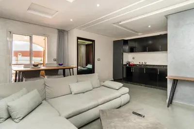 a living room with a white couch and a kitchen at Beautiful central apartment in Marrakech