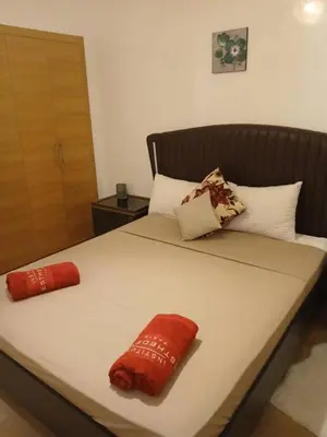 a bed with red and white pillows on it at appartement-prestigia-saphir-marrakech in Marrakech