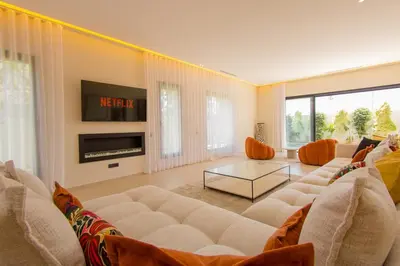 a living room with a white couch and a tv at Beautiful new villa with private pool in El Rhechat