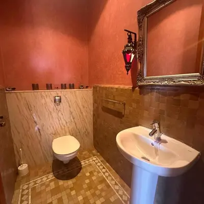 a bathroom with a sink and a toilet and a mirror at L'Oasis Chic Palmeraie Marrakech Piscine & Petit Déj Offert in Marrakech